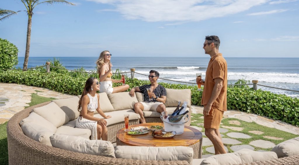 A group of friends sitting at LUNA Beach Club with beachfront views.