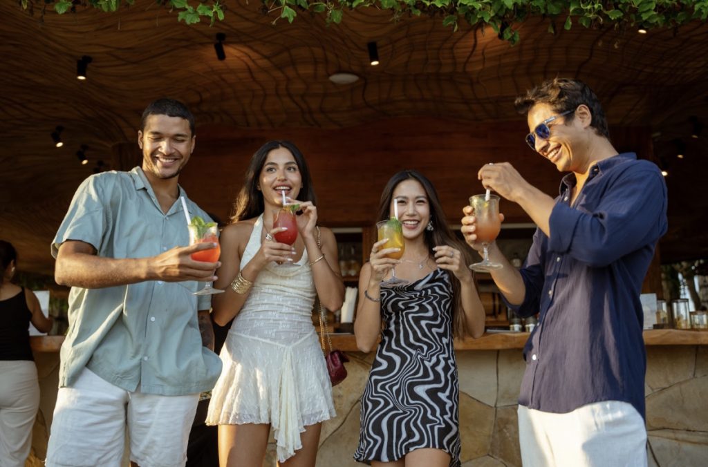 A group of friends drinking cocktails at Luna Beach Club Bar.